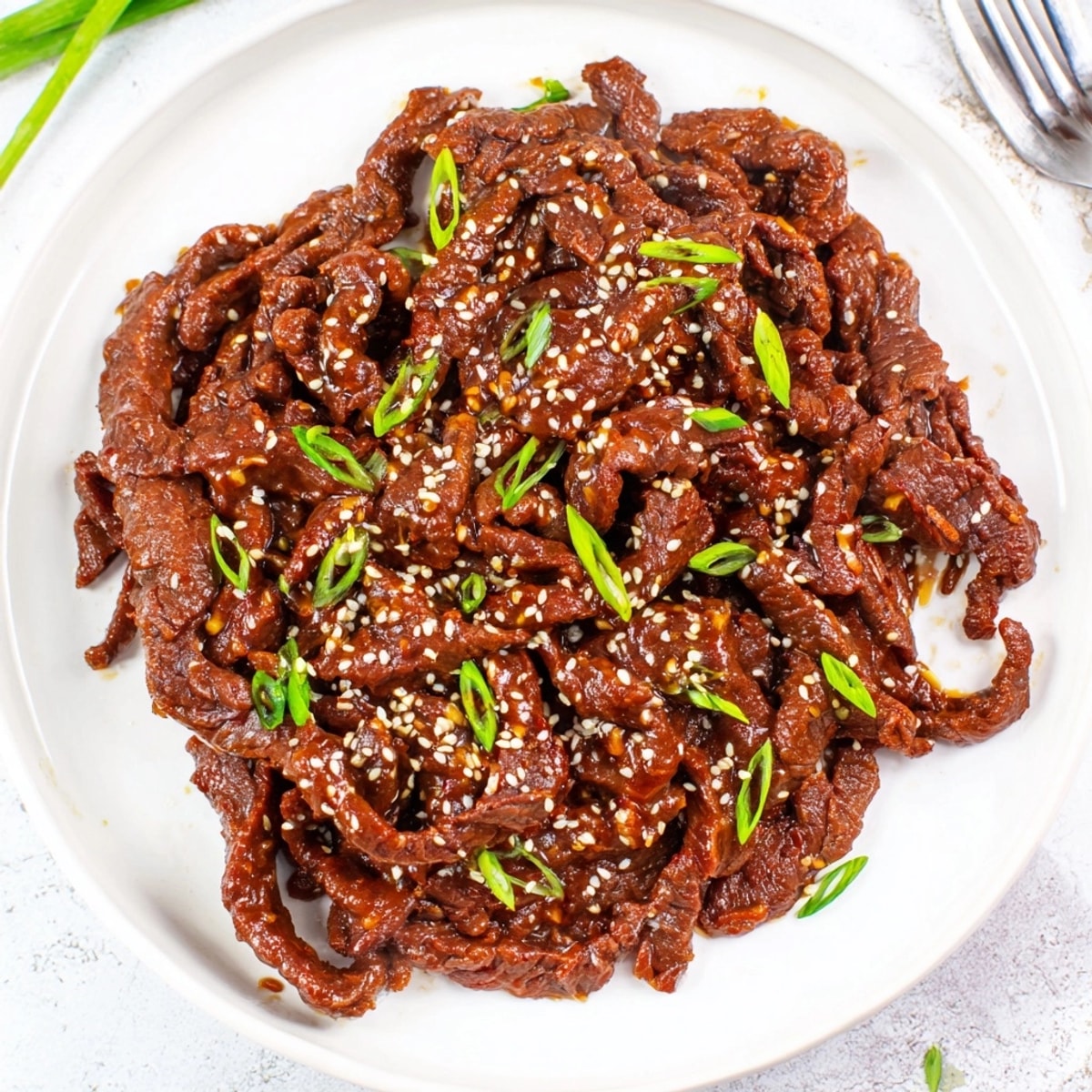 Close-up of glistening Slow Cooker Honey Garlic Beef, ready to serve over fluffy rice.