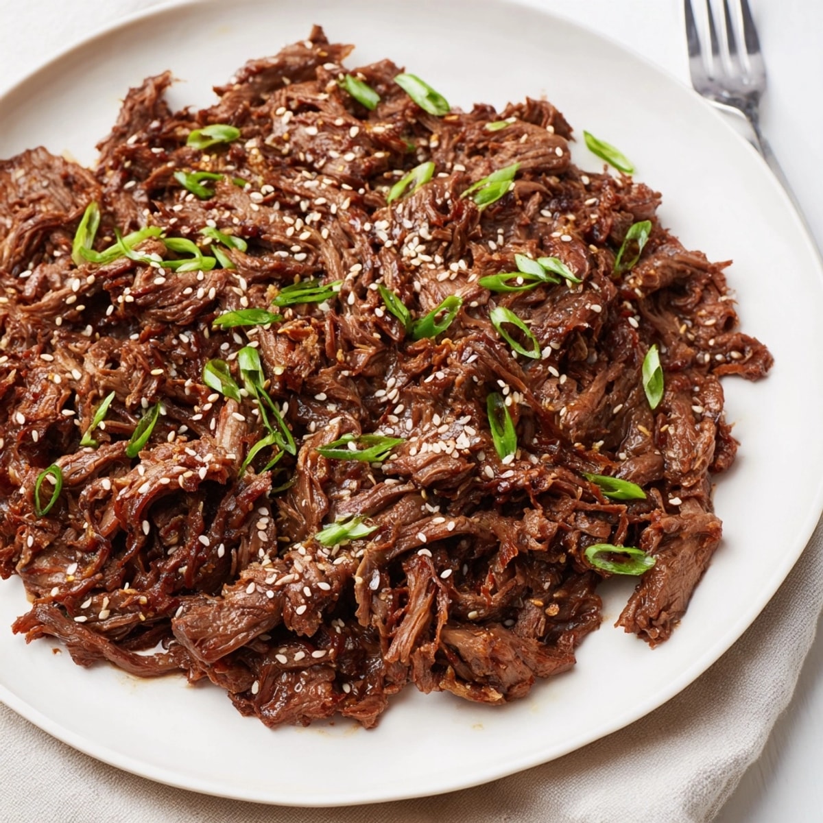 Homemade Slow Cooker Honey Garlic Beef, steaming and fragrant, garnished with green onions.
