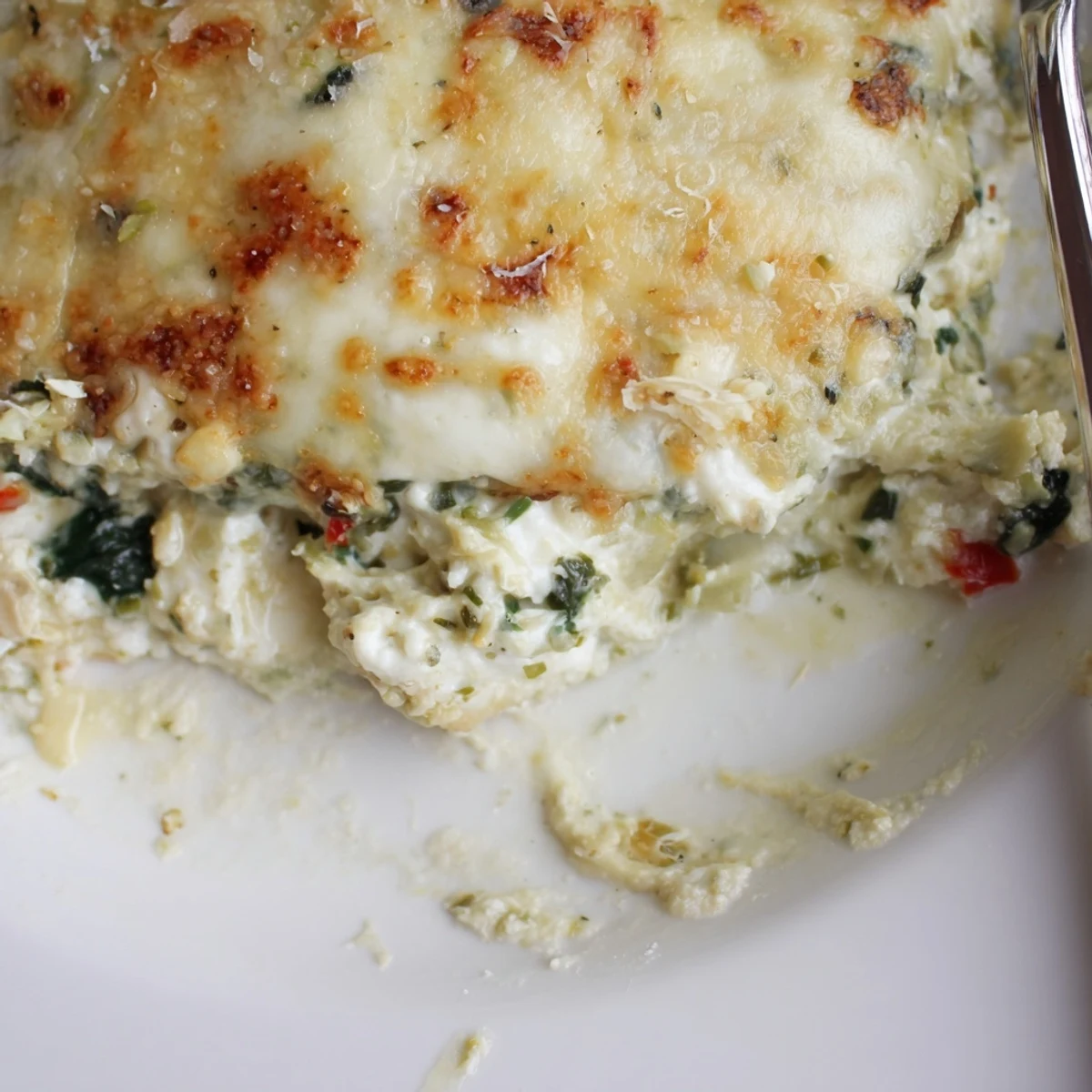 Savory Cheesy Spinach and Artichoke Bake garnished with fresh herbs, perfect with toasted baguette.  