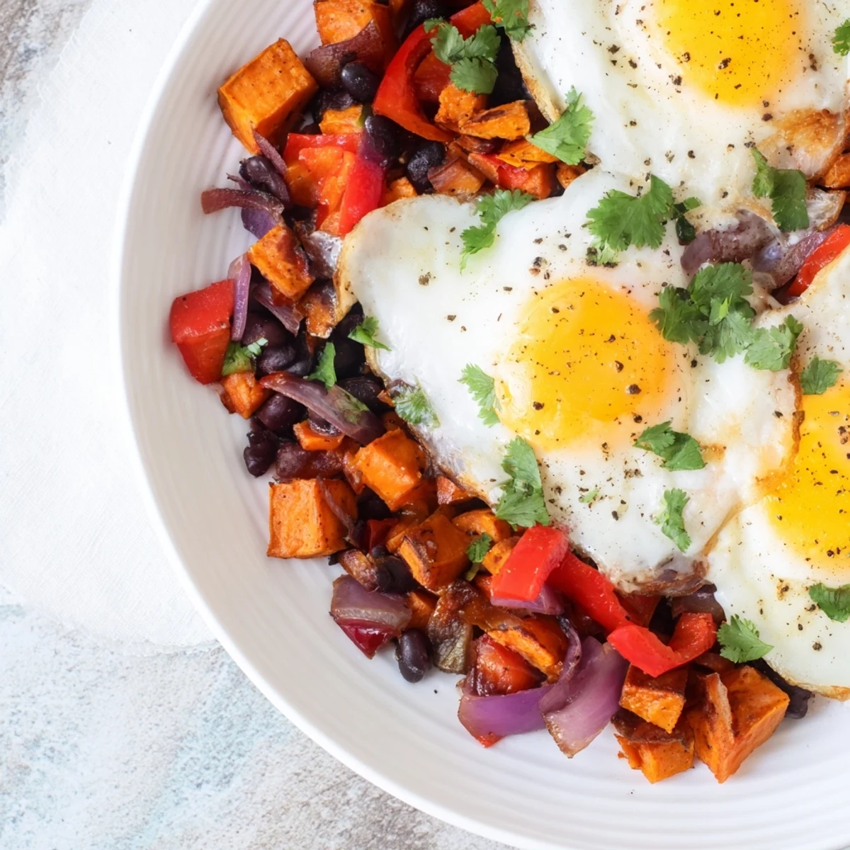 This Sweet Potato & Black Bean Breakfast Hash is a hearty, flavorful dish with a runny egg and fresh cilantro.