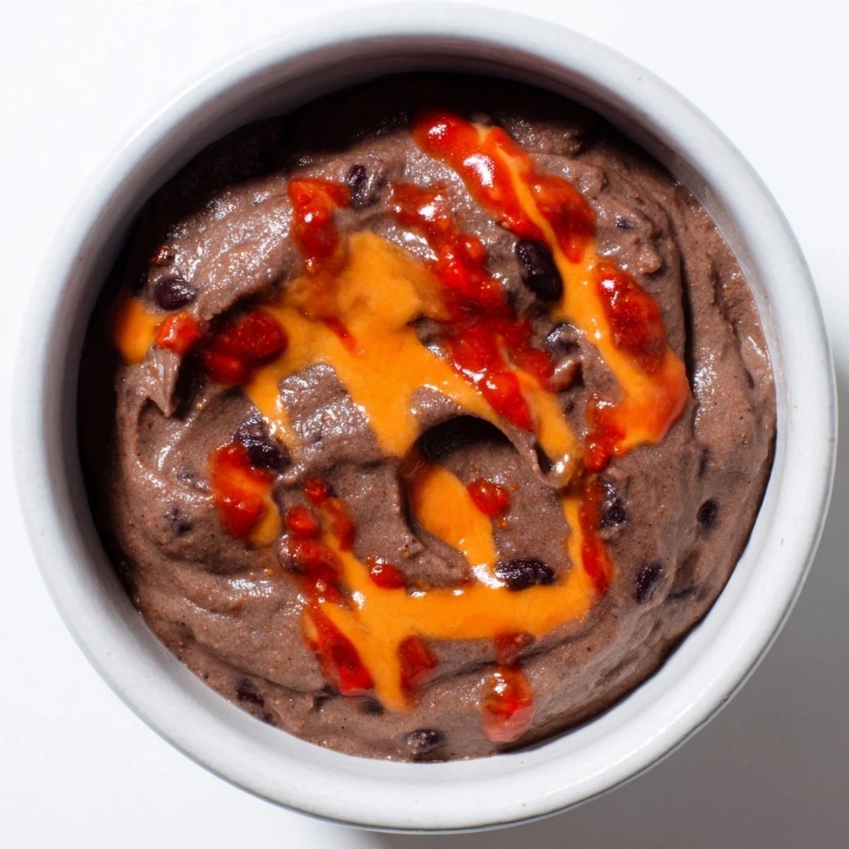 Creamy, vibrant spicy black bean dip ready to scoop with chips, a flavorful party appetizer.