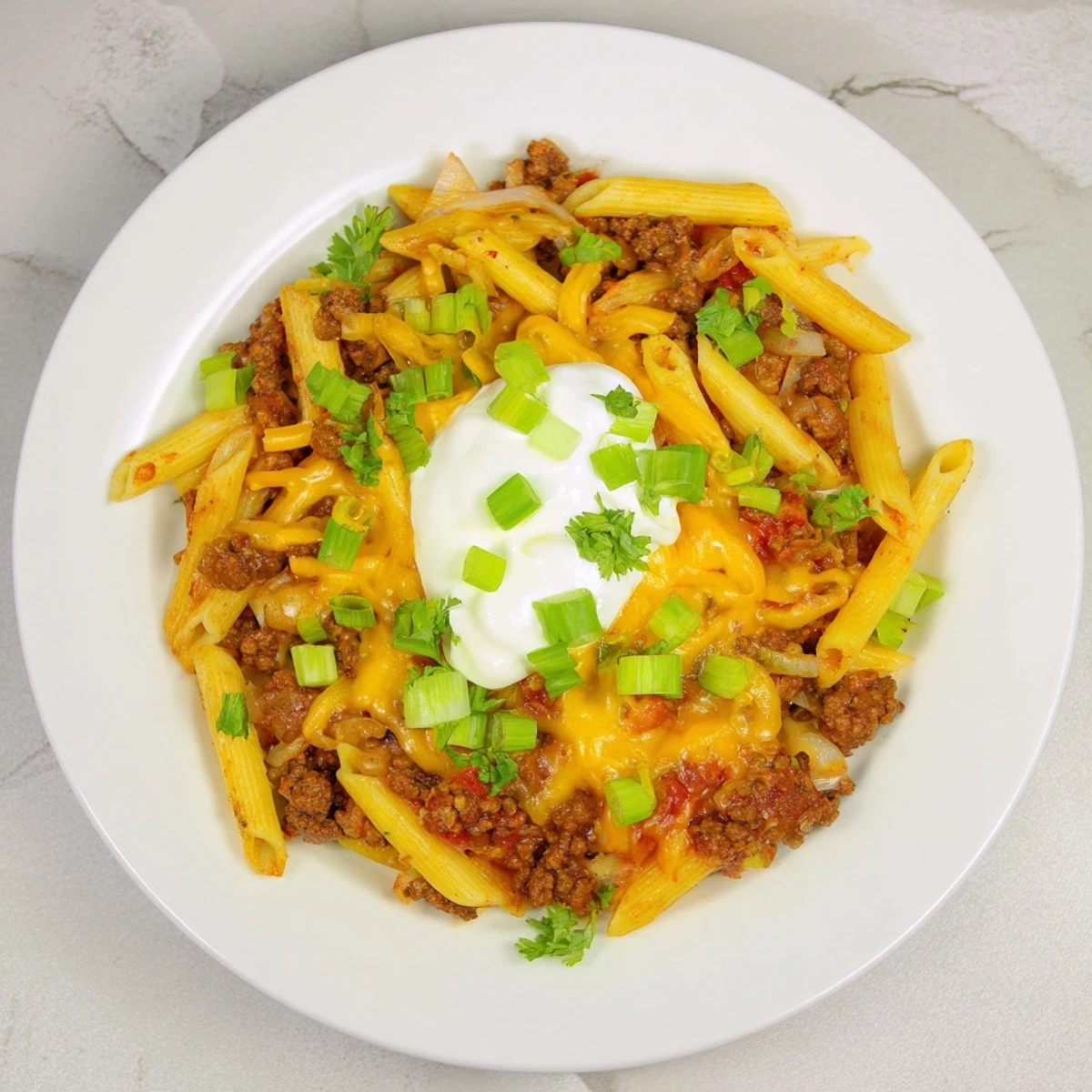 Enjoy the delicious aroma of this Easy Beef Enchilada Pasta with its melted cheese and flavorful Mexican spices.