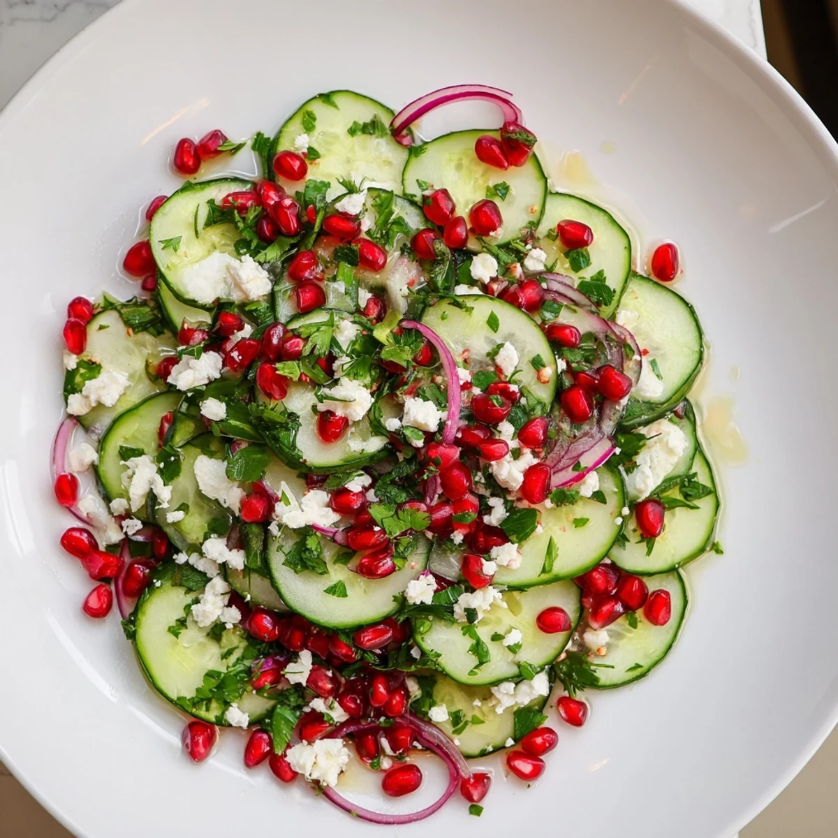 Healthy Cucumber Christmas Salad, a vibrant mix of cucumbers, pomegranate, and citrus dressing ready to serve.