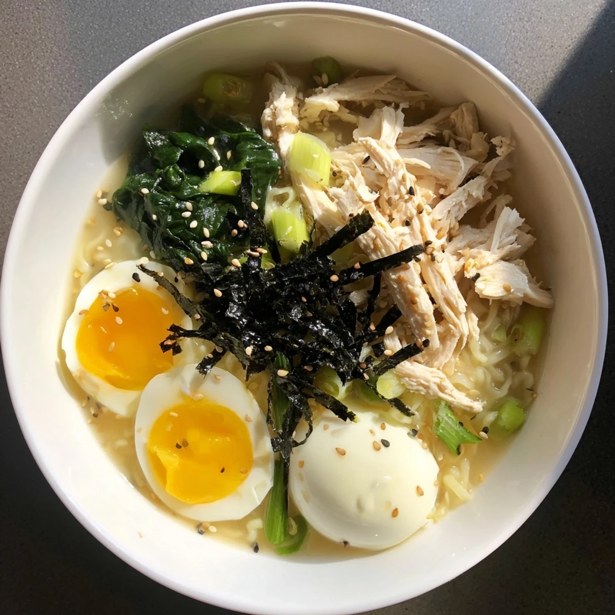Steaming bowl of Chicken Ramen with Kewpie Mayo, garnished with a vibrant soft-boiled egg and scallions.