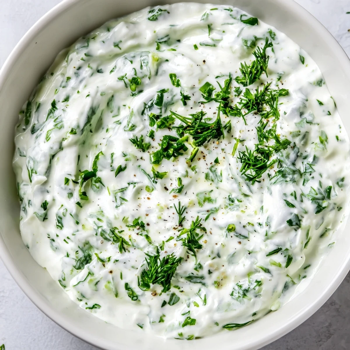 Bright Mediterranean Greek Yogurt Herb Dip in a serving dish, surrounded by vibrant carrots, cucumbers, and bell pepper slices.