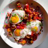 Sizzling skillet of Sweet Potato & Black Bean Breakfast Hash, a vegetarian breakfast filled with vibrant vegetables and savory spices.