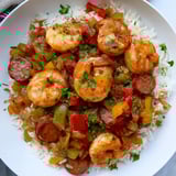 A steaming skillet of vibrant Jambalaya, showcasing shrimp and sausage with vegetables and rice.