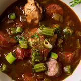 A steaming bowl of comforting Gumbo Okra Soup, garnished with fresh herbs, and a side of rice.
