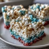 Festive red, white, and blue Rice Krispies treats stacked in patriotic layers, perfect for 4th of July celebrations.