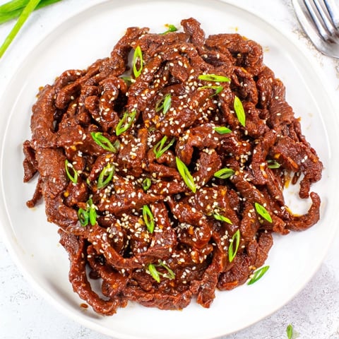 Close-up of glistening Slow Cooker Honey Garlic Beef, ready to serve over fluffy rice.