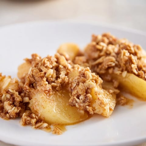Golden-brown Apple Crisp with frozen apples, bubbling fruit beneath a crispy oat topping.