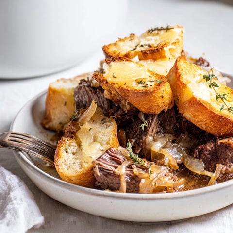 Tender French Onion Pot Roast Casserole bubbling with melted Gruyère, inviting you to dig in.