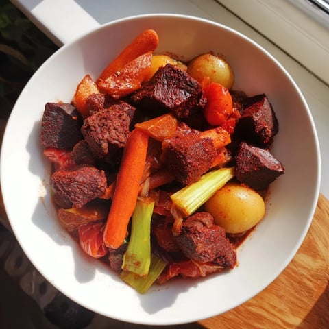 A steaming bowl of Smoked Paprika & Garlic Beef Stew with tender beef and vibrant vegetables.