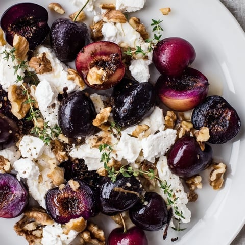 The Midnight Orchard appetizer platter: deep red cherries and creamy goat cheese arranged elegantly.