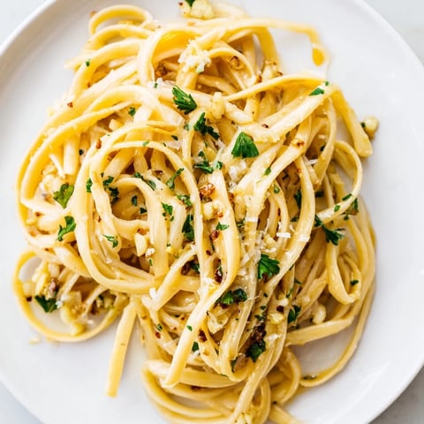 Sizzling garlic butter linguine, ready to serve with fresh parsley and a wedge of lemon.