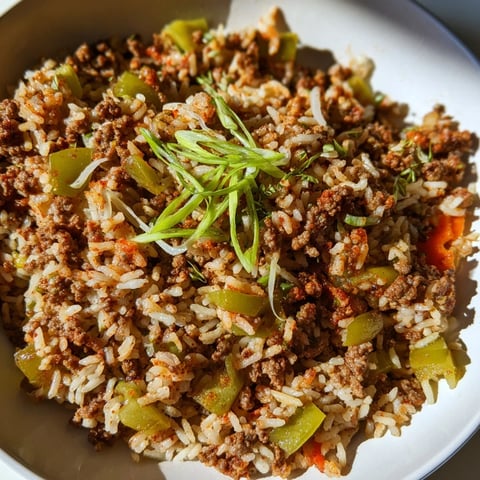 A steaming skillet of Cajun Dirty Rice, a hearty Southern dish with savory meat and spice.