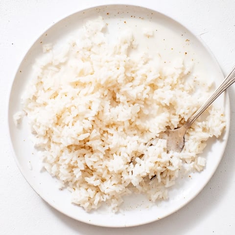 Steaming Coconut Jasmine Rice in a white bowl, offering a creamy, delicious Southeast Asian side.