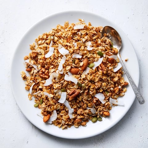 Homemade granola clusters baked to golden perfection, loaded with oats, mixed nuts, and honey for a crunchy snack.  