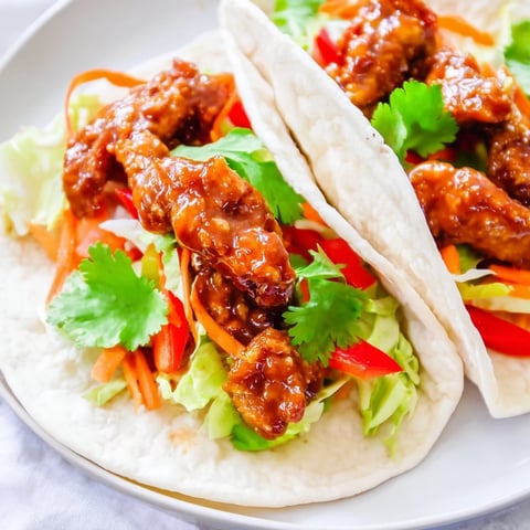 Glazed chicken strips with honey and sriracha nestled in a soft tortilla with crisp vegetables.