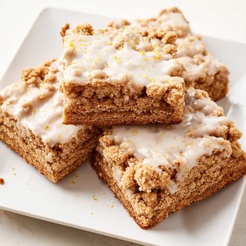 Warm and spiced gingerbread bars under a buttery crumble and bright lemon glaze – a sweet delight.