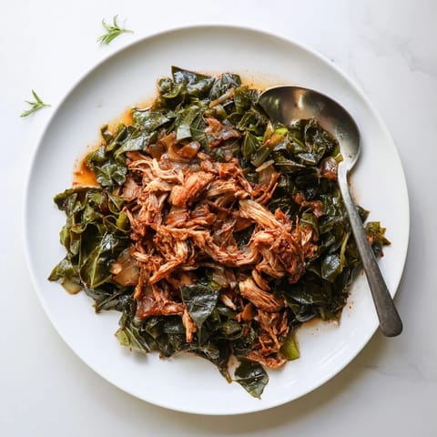 A steaming bowl of Southern collard greens with flavorful smoked turkey, perfect for a cozy supper.