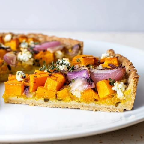 Golden-crusted Feuille d'Erable tart, filled with roasted veggies and creamy goat cheese, ready to serve.