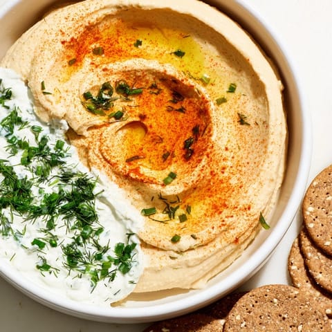 This image shows delicious Easy Dips, with colorful herbs and spices next to crunchy crackers.