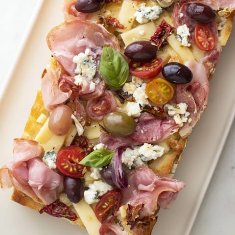 Golden-baked flatbreads, The Rustic Raft, are piled high with meats, cheeses, and fresh accompaniments.