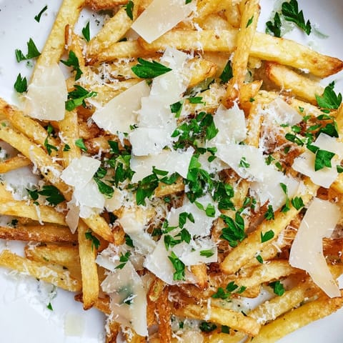 Freshly cooked Truffle Parmesan Fries served hot, with a rich umami aroma and melted cheese on golden potatoes for a decadent snack.