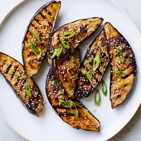 Golden miso glazed eggplant brushed with savory glaze, served warm beside fluffy white rice.