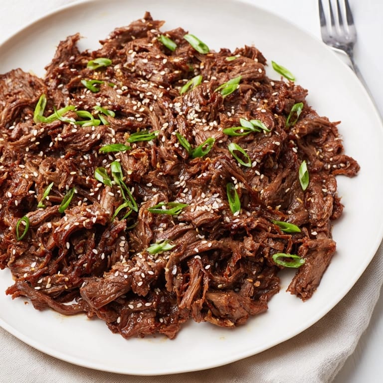 Homemade Slow Cooker Honey Garlic Beef, steaming and fragrant, garnished with green onions.