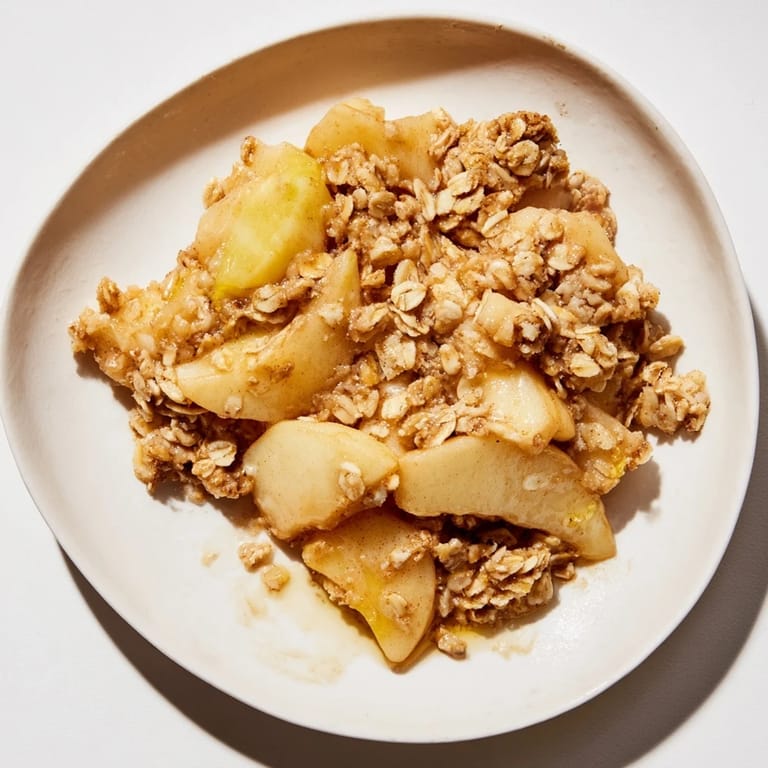 A close-up of freshly baked Apple Crisp, highlighting the sweet, cinnamon-infused frozen apples.