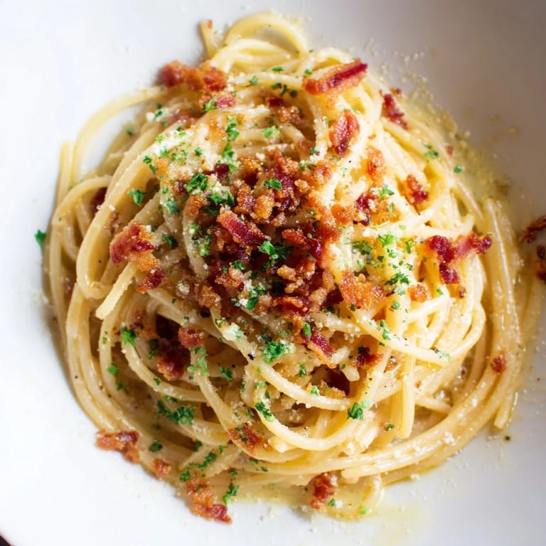 Tender pasta coated in garlic butter sauce, sprinkled with golden, crumbled bacon, perfect for Garlic Butter Pasta.