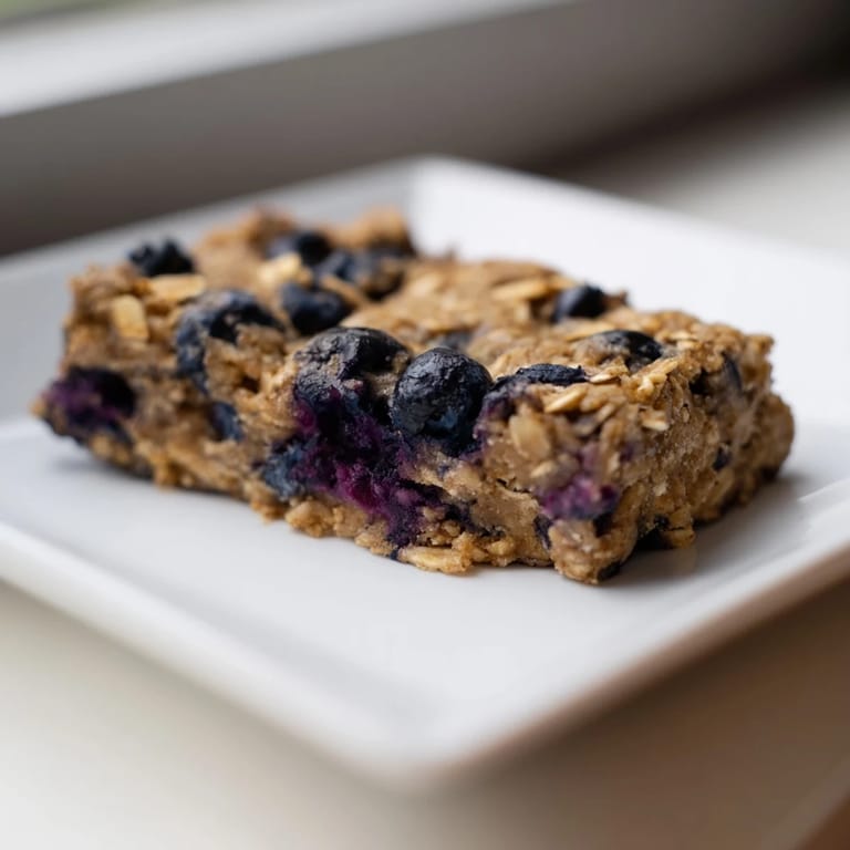 Freshly baked Blueberry Banana Oatmeal Protein Bars, fragrant with cinnamon, perfect for a quick snack.