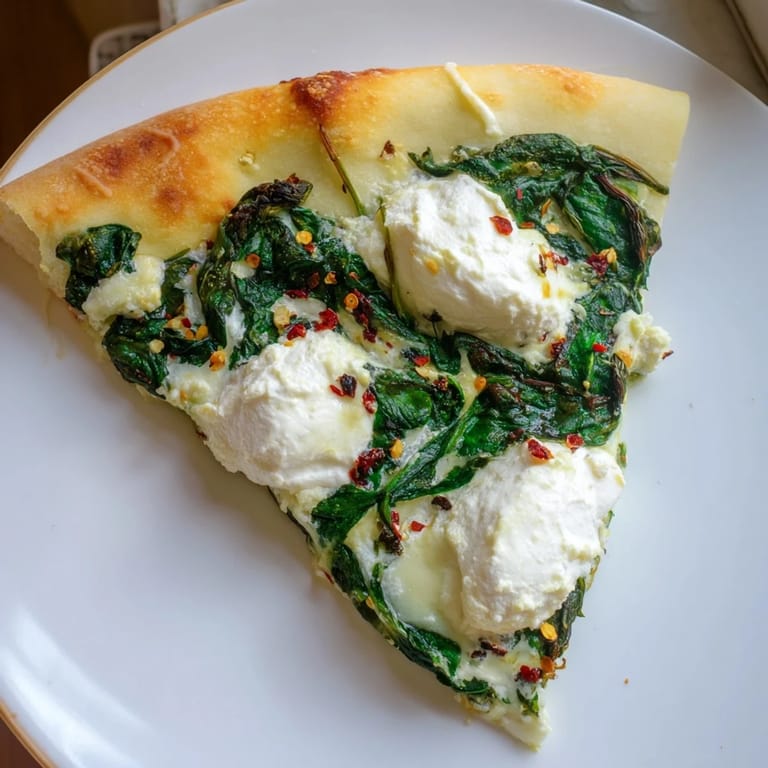 Garlic butter brushed on a hot spinach ricotta pizza, topped with creamy ricotta and fresh herbs.