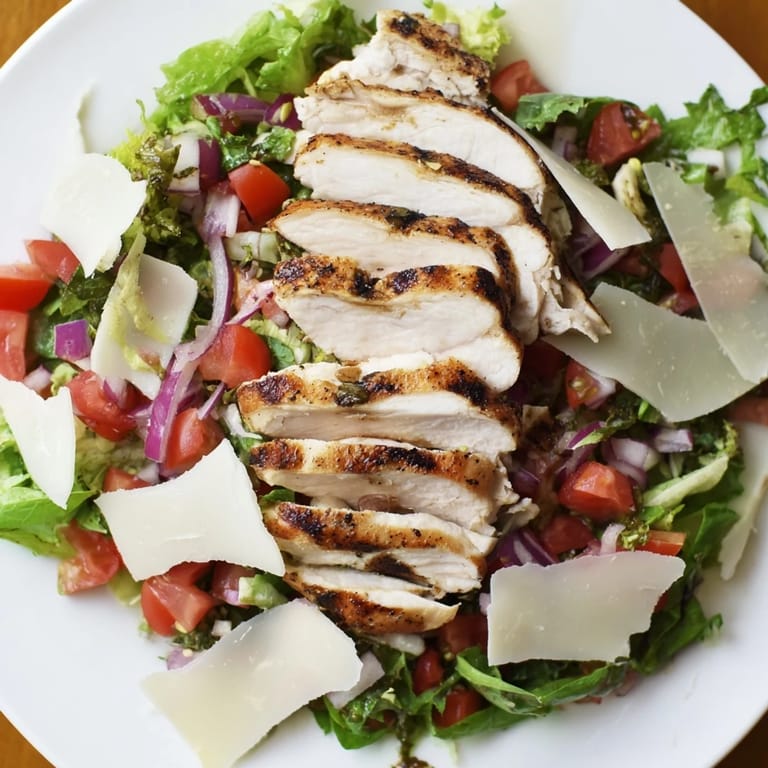 Spoon a zesty bruschetta topping over sliced chicken and crisp greens in this fresh Bruschetta Chicken Salad.