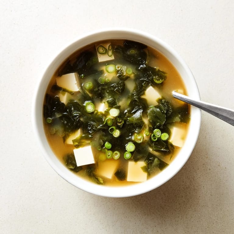 Steaming Japanese wakame soup in a white bowl with tender seaweed and cubed tofu.