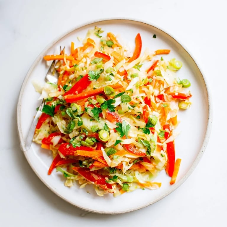 Freshly tossed Sauerkraut Slaw in a rustic ceramic bowl, packed with crunchy green cabbage, carrots, and a light tangy dressing for a healthy side dish.