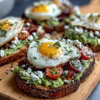 Spring brunch avocado toast board with toppings, featuring creamy mashed avocado on sourdough, colorful radish slices, cherry tomatoes, and microgreens for a vibrant spread.